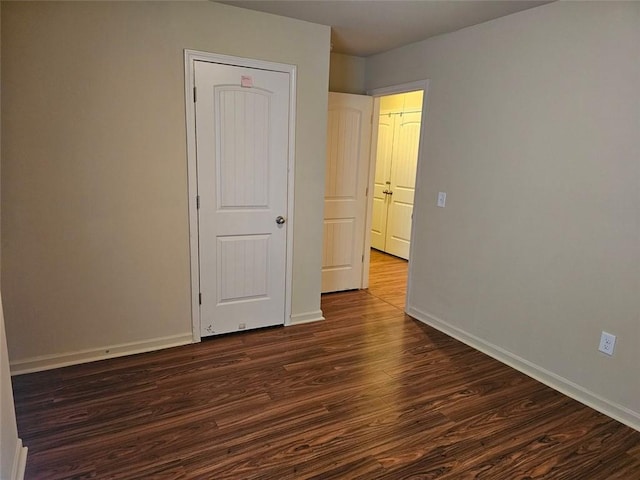 empty room with dark hardwood / wood-style flooring