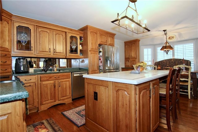 kitchen featuring a sink, glass insert cabinets, brown cabinets, and appliances with stainless steel finishes