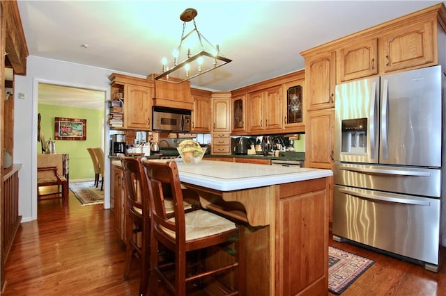 kitchen featuring light countertops, an inviting chandelier, hanging light fixtures, stainless steel appliances, and dark wood-style flooring