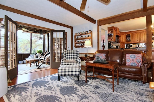 living room featuring ceiling fan, beamed ceiling, wood finished floors, and french doors