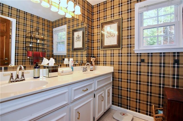 full bath with tile patterned floors, double vanity, wallpapered walls, and a sink