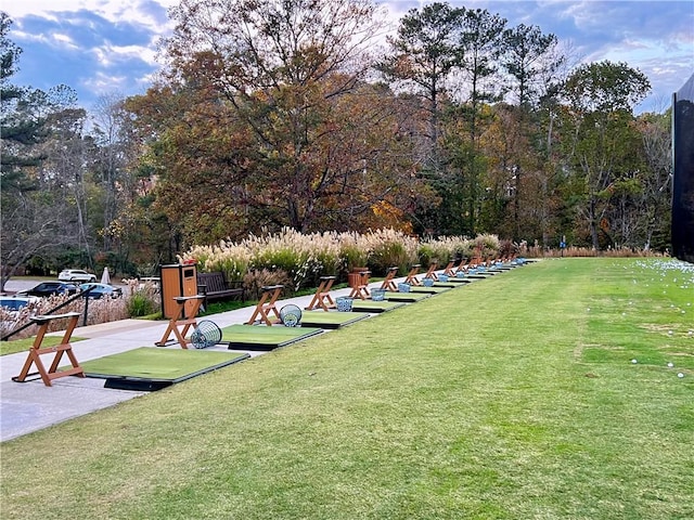 view of community with a lawn and a wooded view