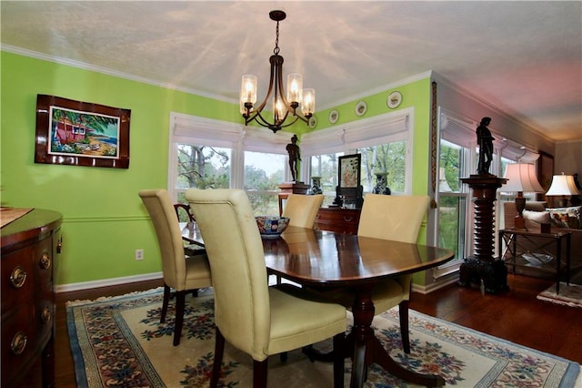 dining space with a chandelier, baseboards, wood finished floors, and crown molding