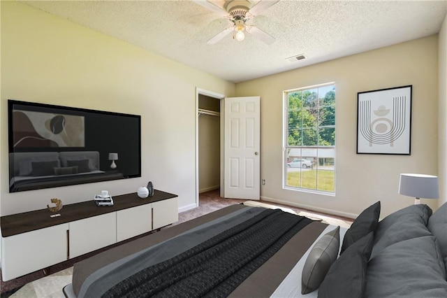 6445 Marsham Dr, Atlanta, GA 30349 - carpeted bedroom featuring a textured ceiling, baseboards, a ceiling fan, and a closet