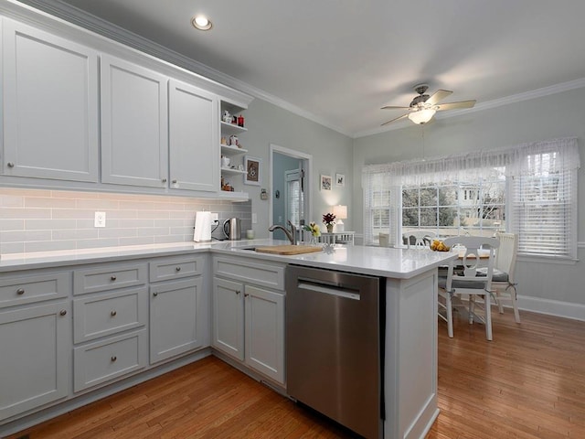 kitchen with sink, crown molding, kitchen peninsula, and dishwasher