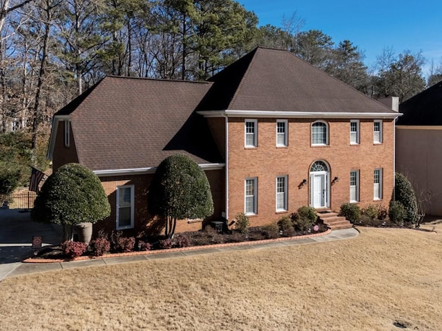 colonial home featuring a front lawn