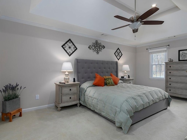 carpeted bedroom with a tray ceiling, ornamental molding, and ceiling fan