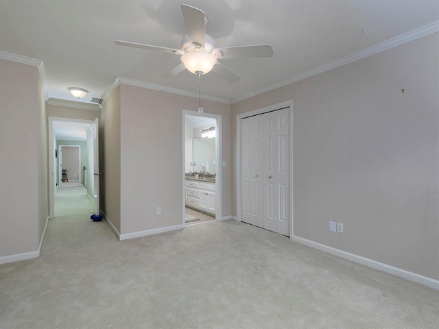 unfurnished bedroom featuring ceiling fan, connected bathroom, ornamental molding, light colored carpet, and a closet