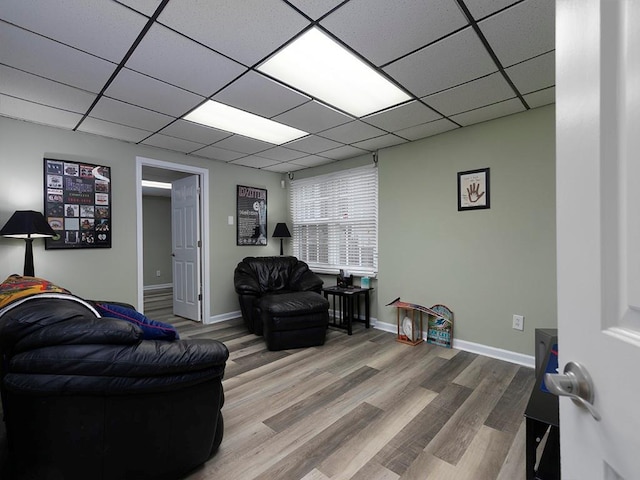 living room featuring hardwood / wood-style floors and a drop ceiling