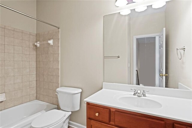 full bathroom with tiled shower / bath, vanity, and toilet