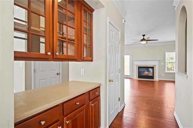 bar with ornamental molding, ceiling fan, and dark wood-type flooring