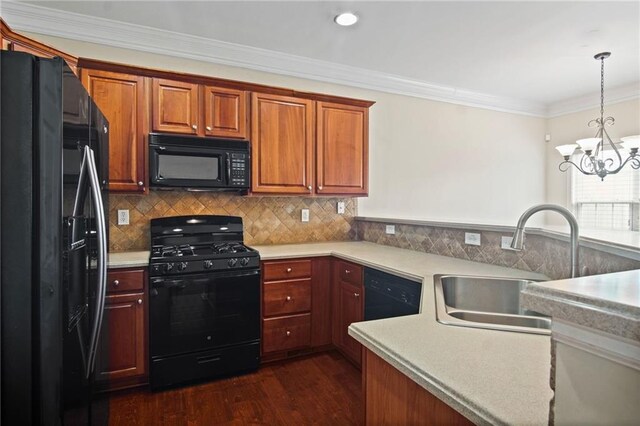 kitchen featuring pendant lighting, sink, dark wood-type flooring, black appliances, and a notable chandelier