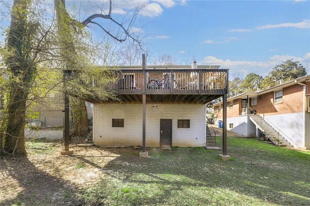 rear view of house with a deck, stairway, and a lawn