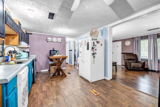 131 W Blue Branch Rd, Eatonton, GA 31024 - kitchen with white appliances, blue cabinetry, dark wood-type flooring, and a textured ceiling