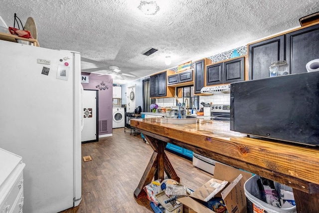 131 W Blue Branch Rd, Eatonton, GA 31024 - kitchen with freestanding refrigerator, washer / clothes dryer, under cabinet range hood, wood finished floors, and a ceiling fan