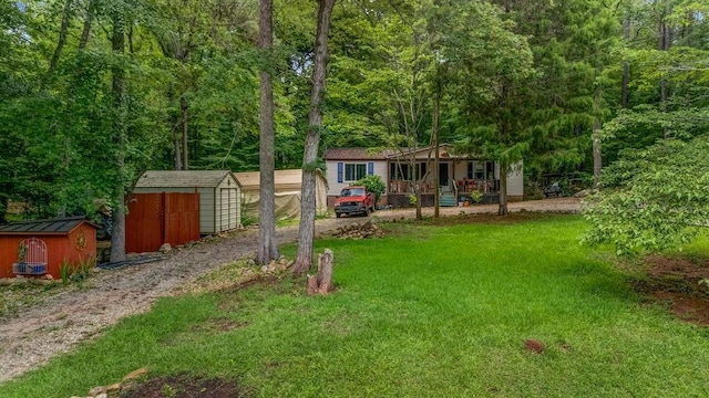 131 W Blue Branch Rd, Eatonton, GA 31024 - view of green lawn featuring a storage unit, covered porch, and a view of trees