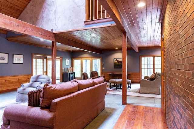 living room featuring wood walls, wooden ceiling, light hardwood / wood-style floors, beamed ceiling, and a healthy amount of sunlight