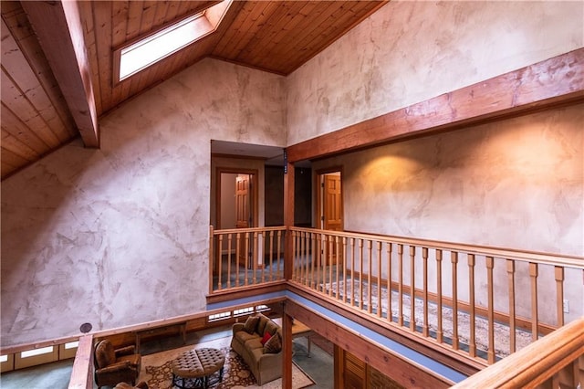 interior space with wood ceiling, high vaulted ceiling, and a skylight