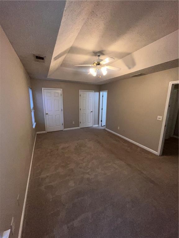 142 Benfield Cir, Cartersville, GA 30121 - unfurnished bedroom with ceiling fan, carpet, a textured ceiling, and a raised ceiling