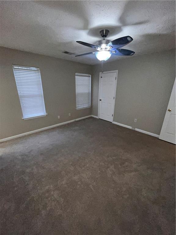 142 Benfield Cir, Cartersville, GA 30121 - unfurnished bedroom with ceiling fan, a textured ceiling, and dark colored carpet