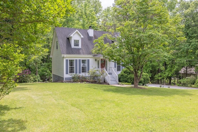 cape cod house featuring a chimney and a front lawn