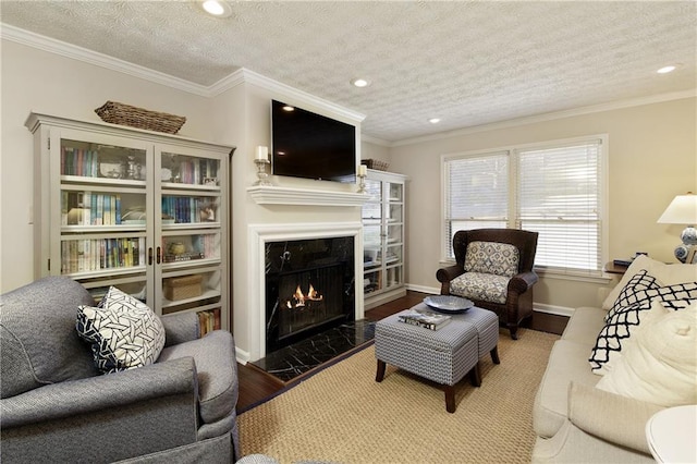 living room with crown molding, a textured ceiling, wood finished floors, and a high end fireplace