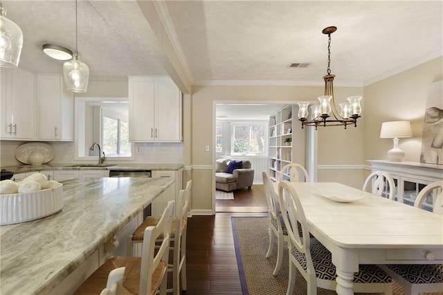 dining room with ornamental molding, visible vents, dark wood finished floors, and a notable chandelier