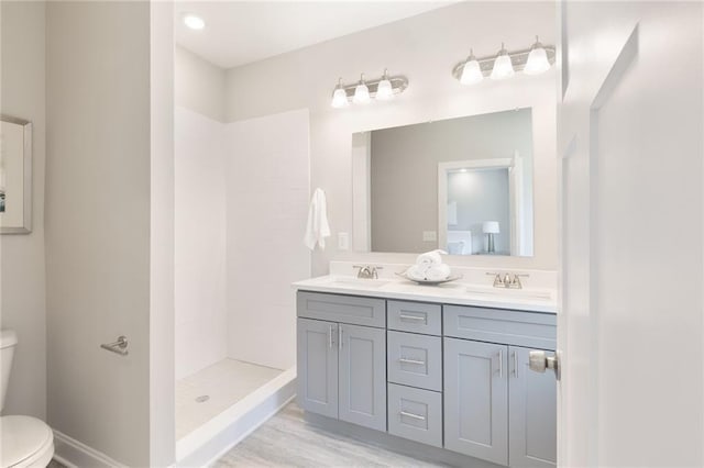 3810 Jack Vernon Cir, Powder Springs, GA 30127 - bathroom with toilet, double vanity, tiled shower, and wood finished floors