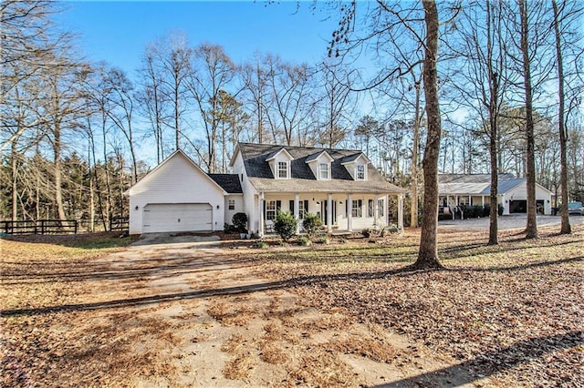 new england style home featuring a garage and a porch