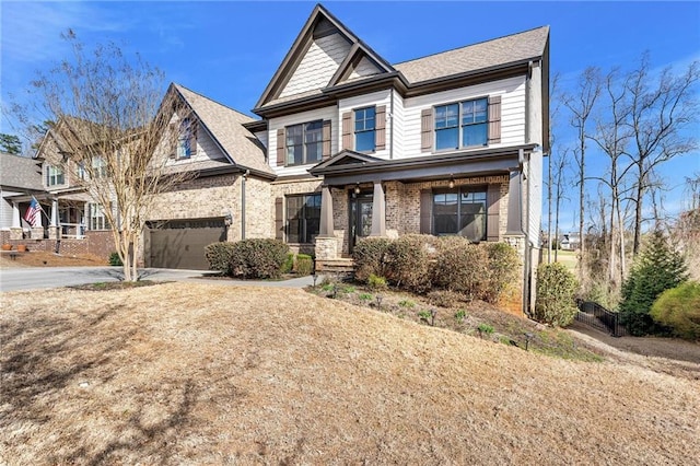 craftsman-style home with brick siding, driveway, and an attached garage