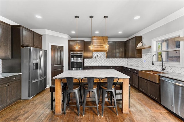 kitchen featuring a sink, crown molding, dark brown cabinets, and stainless steel appliances