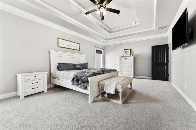 bedroom with a raised ceiling, carpet flooring, crown molding, and baseboards