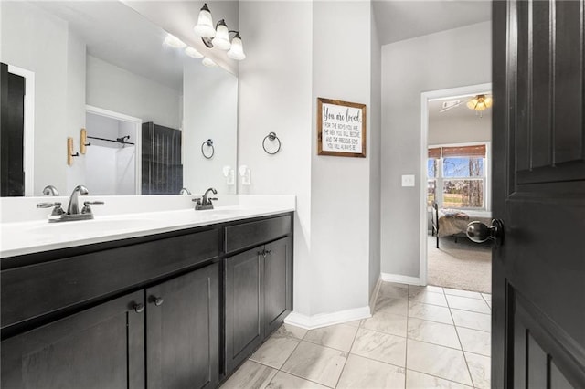 bathroom featuring a sink, baseboards, and double vanity