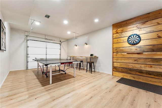 rec room featuring recessed lighting, wood finished floors, a garage, and baseboards