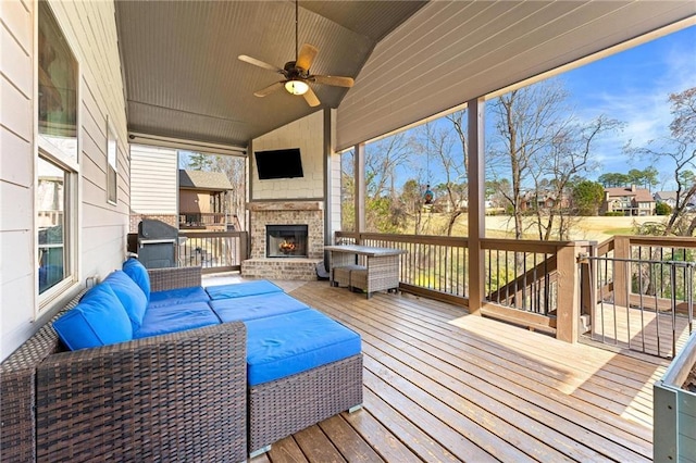 wooden terrace featuring an outdoor living space with a fireplace, grilling area, and ceiling fan