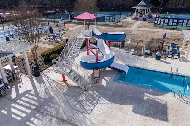 pool featuring a patio area, a water slide, and fence