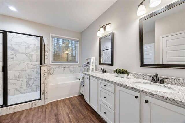 bathroom featuring vanity, a stall shower, wood finished floors, and a bath