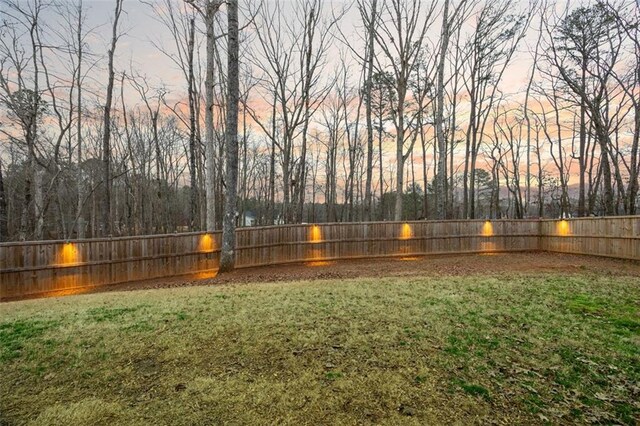 patio terrace at dusk featuring a grill, fence, a ceiling fan, and area for grilling