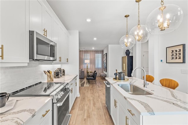 kitchen featuring stainless steel appliances, white cabinetry, and sink