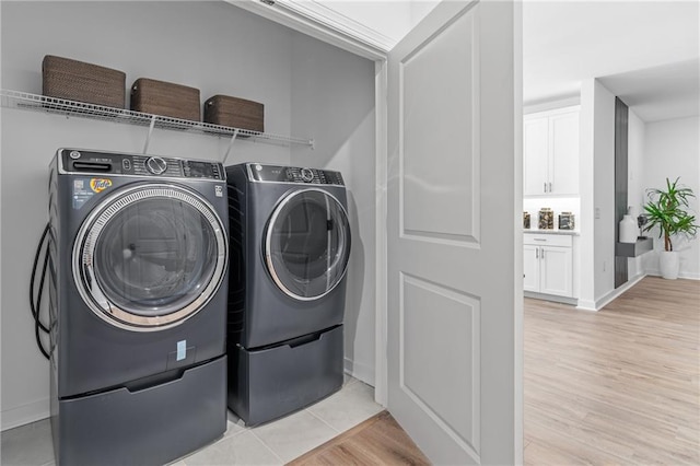 laundry room with light hardwood / wood-style floors and washing machine and clothes dryer