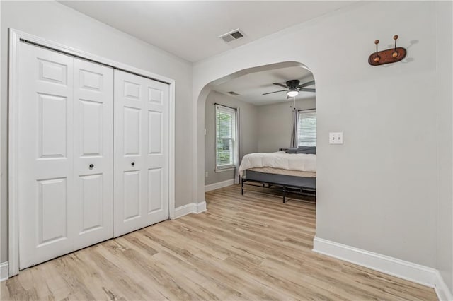 58 Hampton Forest Ct, Dahlonega, GA 30533 - bedroom with arched walkways, baseboards, light wood-style flooring, and a closet