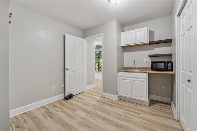 58 Hampton Forest Ct, Dahlonega, GA 30533 - kitchen with black microwave, light wood finished floors, white cabinets, open shelves, and baseboards