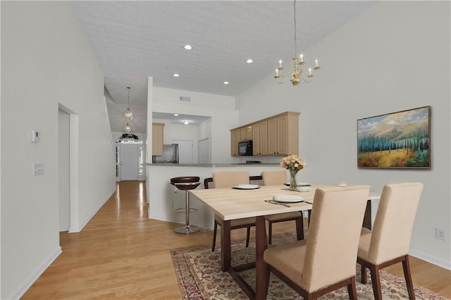 dining space with a high ceiling and light wood-type flooring