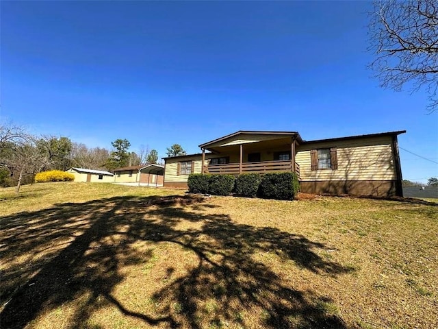 back of house with covered porch and a yard