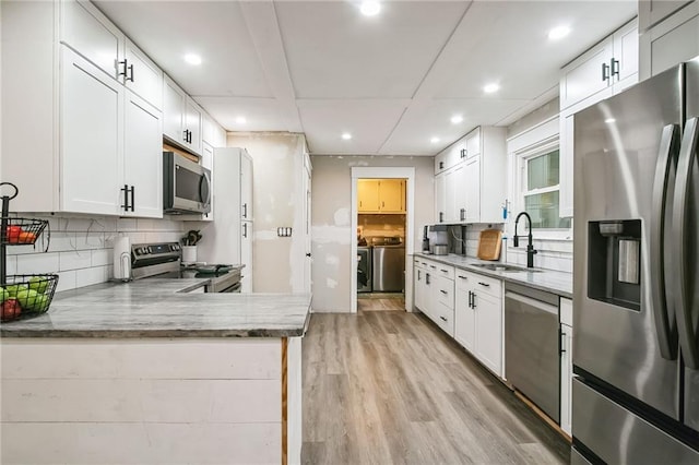 315 Charlotte Blvd, Stockbridge, GA 30281 - kitchen featuring stainless steel appliances, a sink, washer and dryer, recessed lighting, and light wood-style floors