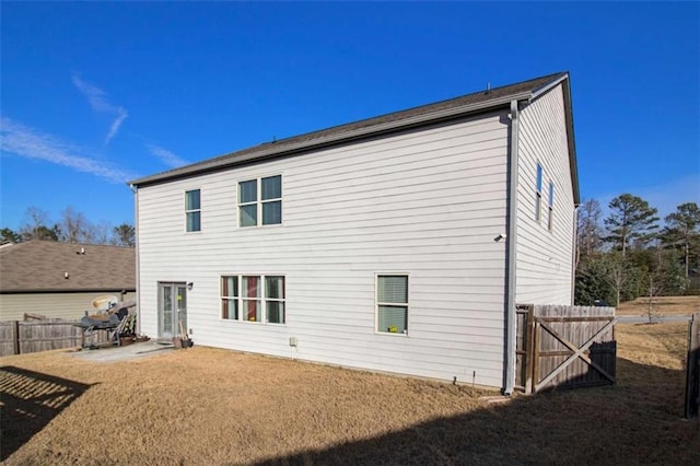 back of property with a lawn and a patio