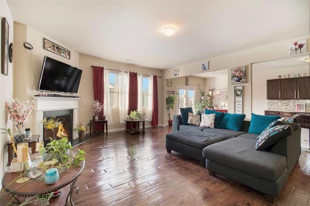 living room with dark hardwood / wood-style flooring and an inviting chandelier