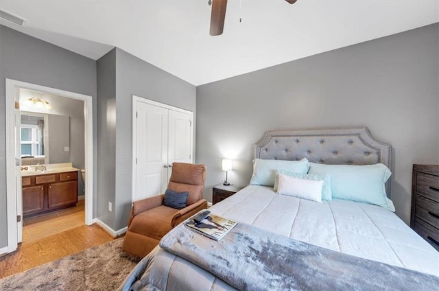 bedroom featuring ceiling fan, light wood-type flooring, and ensuite bathroom