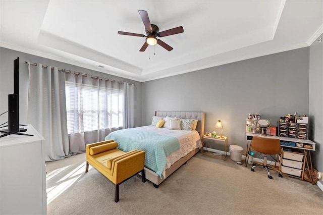 bedroom with light colored carpet, a raised ceiling, and ceiling fan