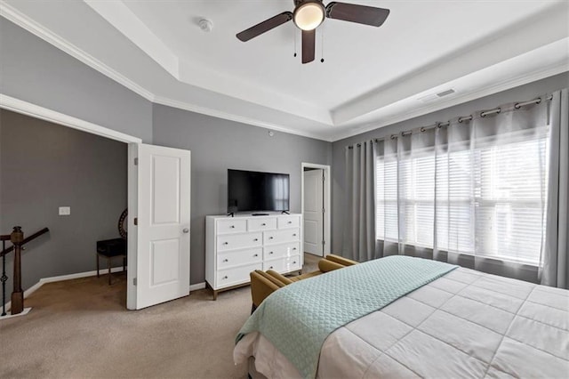 carpeted bedroom featuring a tray ceiling, ceiling fan, and ornamental molding